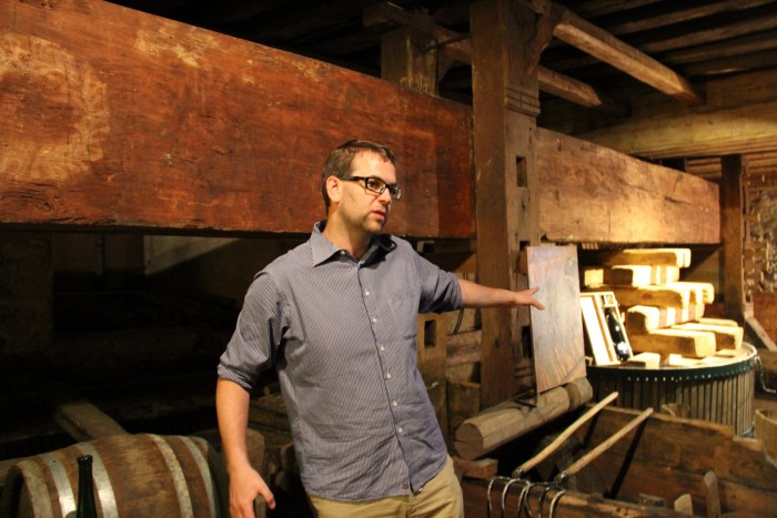 Nikolaus Saahs stands in front of a 350-year-old beam press