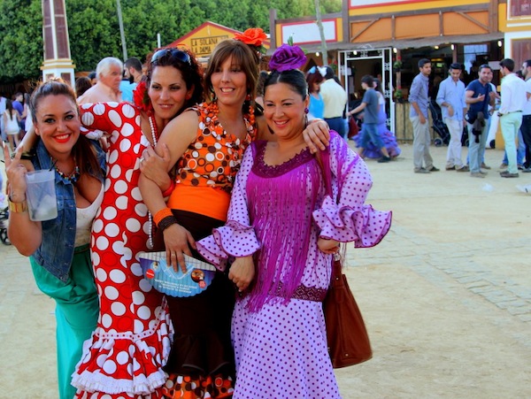 Four women at the annual Feria de Caballo in Jerez de la Frontera pose for a photo on their way to enjoying a pitcher of rebujitos made with fino sherry.